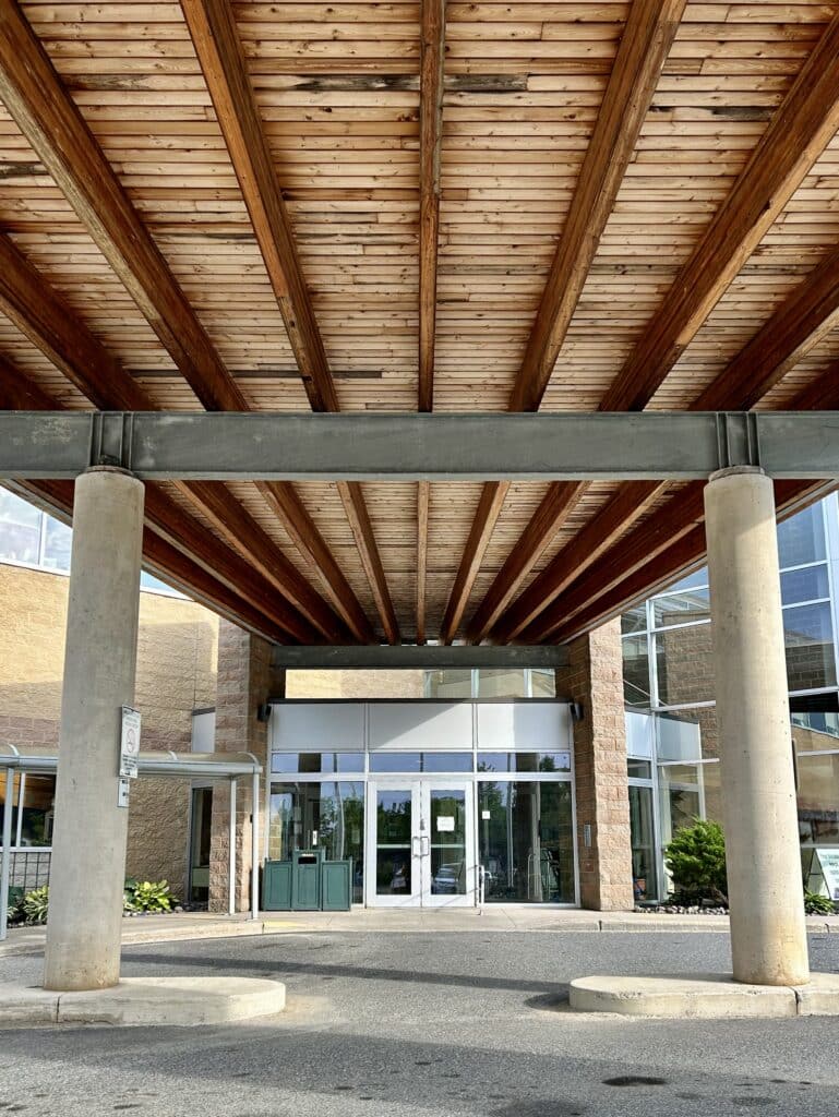 The main entrance welcomes visitors and is surrounded by columns holding up the natural wooden roof.